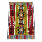 Vintage handwoven Turkish Eşme kilim rug with a bright green center field featuring geometric medallions and deep red borders. Small boho area rug or wall hanging in green, red, and blue wool.